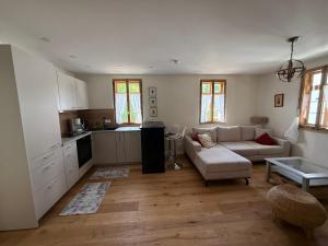 a living room with a couch and a kitchen at Wohnen im Denkmal in Weilrod +4 photos