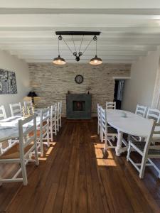 a dining room with white tables and chairs and a fireplace at Gîte de la Vallée du Don in Guéméné-Penfao