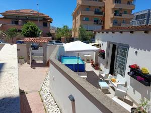 a patio with chairs and an umbrella on a building at B&B Purple Italy in Fiumicino