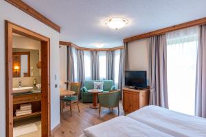 a hotel room with a bed and a bathroom at Landhaus Grünau in Wals