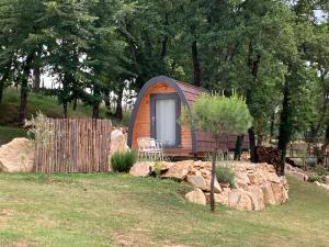 a tiny house in a yard with rocks and trees at POD Nature 2 in Chazelles +2 photos