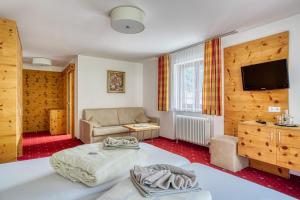 a living room with a bed and a couch at Hotel Jägerhof Ötz in Oetz