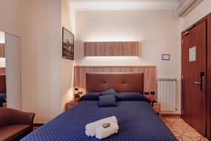 ein Schlafzimmer mit einem blauen Bett, auf dem zwei Handtücher liegen in der Unterkunft Hotel Stella in Rapallo