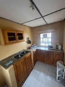 a kitchen with a sink and a microwave at Fayes Afrikaans huisje Brusubi in Brusubi