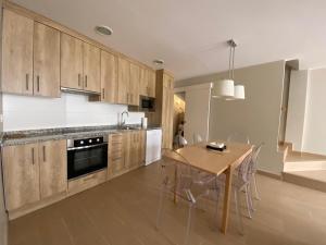 a kitchen with wooden cabinets and a table with chairs at Apartamento Casa Francho in Panticosa