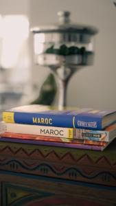 a stack of books sitting on top of a table at Maison d'hôtes Kamilia in Ksar es Sghir
