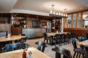 a restaurant with wooden tables and chairs at Hotel am Haidel in Hinterschmiding