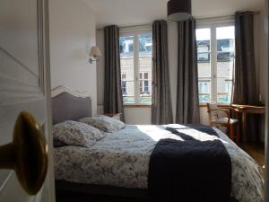 a hotel room with a bed and a window at Le Charme à la Française in Honfleur