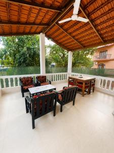 a patio with chairs and tables and a ceiling at Coconut Sky 2Bhk Penthouse Baga in Baga