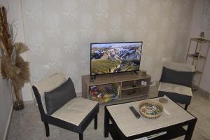 a living room with a tv and two chairs and a table at Floor in Alexandroupoli