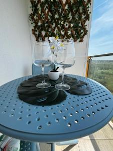 a blue table with two wine glasses on it at My Blaxy apartment in Olimp