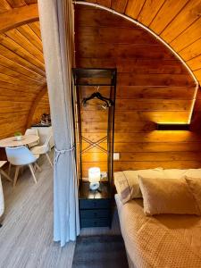a bedroom with a bed and a wooden wall at Bungalow de Quintas in Marco de Canaveses