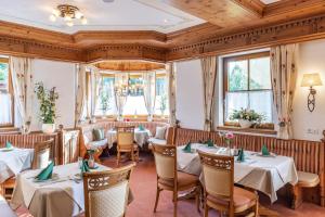 a restaurant with tables and chairs and windows at Landhaus Grünau in Wals