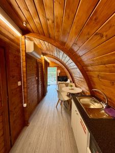 a kitchen and dining room with a wooden ceiling at Bungalow de Quintas in Marco de Canaveses