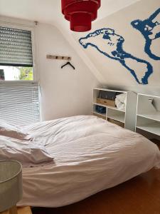 a bedroom with a bed with a map on the wall at Pavillon des Chouettes in Brech