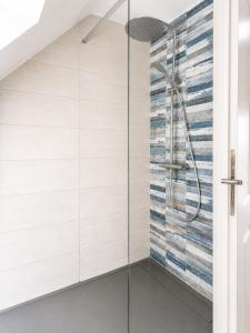 a glass shower in a bathroom with white tiles at Pavillon des Chouettes in Brech +8 photos