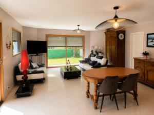 a living room with a table and a couch at Pavillon des Chouettes in Brech