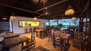 a restaurant with wooden tables and chairs in a room at NoyaAfrika Kendwa Boutique in Kendwa