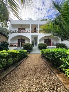 a white house with a pathway in front of it at NoyaAfrika Kendwa Boutique in Kendwa