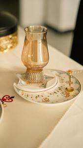 a glass vase on a plate on a table at Maison d'hôtes Kamilia in Ksar es Sghir