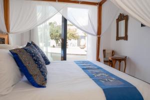 a bedroom with a large bed with a window at Lagoa Beach House B&B - Breakfast included in Serra do Bouro