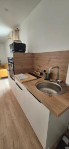 a kitchen with a sink and a wooden counter top at Le Nid Charentais in Cognac