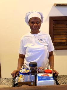 a woman standing in front of a tray of food at NoyaAfrika Kendwa Boutique in Kendwa