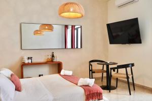 a room with a bed and a table and a tv at Taga Suites in Catania