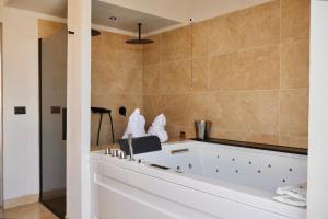 a bathtub in a bathroom with a tile wall at Taga Suites in Catania +114 photos