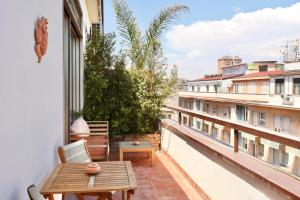 a balcony with a wooden table and a bench at Taga Suites in Catania