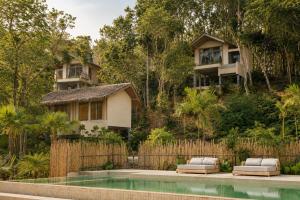 a villa with a swimming pool in front of a house at Amber Yao Noi in Ko Yao Noi