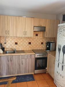 a kitchen with wooden cabinets and a sink and a stove at Gorczyca Reset in Płaska