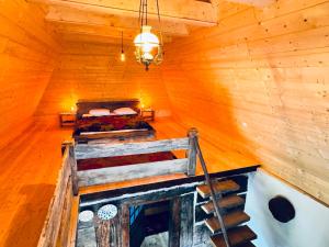 an attic room with a bed in a log cabin at Hafia Legacy in Berbeşti