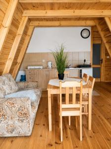 a dining room with a table and a couch at Osada Kujanki - domek wakacyjny in Zakrzewo