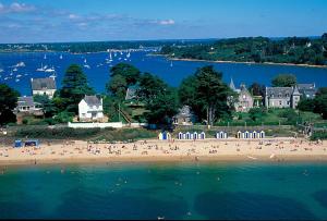 a group of people on a beach near the water at Pavillon des Chouettes in Brech