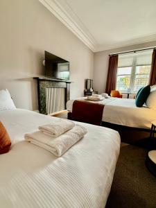 a hotel room with two beds and a fireplace at Linen Bank Residence - Aparthotel in Linlithgow