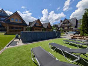 a yard with two lawn chairs and houses at Janulkowe Domki in Zakopane