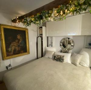 a bedroom with a bed and a painting and lights at Spacious Studio by the sea, Garden & Parking in Marazion