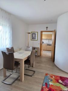 a dining room with a wooden table and chairs at Ferienhaus Maria in Breitengüßbach