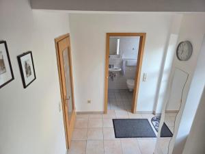 a bathroom with a toilet and a clock on the wall at Ferienhaus Maria in Breitengüßbach +15 photos