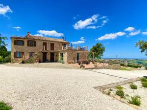 an exterior view of a house with a gravel driveway at Agriturismo Fontelini in Cingoli