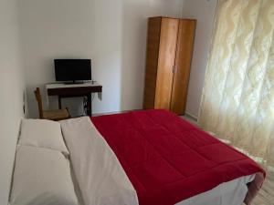 a bedroom with a red and white bed and a desk at Mountain Bloom House in Galda de Sus