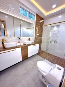 a bathroom with a toilet and two sinks and a mirror at Quinta Samalu in Villavicencio +23 photos