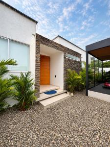 a house with a wooden door and some plants at Quinta Samalu in Villavicencio