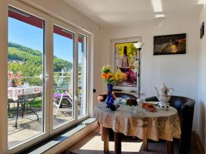 a living room with a table and a balcony at Fewo Helene im Haus Moselwelt in Zell an der Mosel