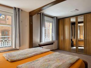 a bedroom with a bed and two windows at Fewo Helene im Haus Moselwelt in Zell an der Mosel