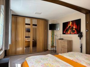 a bedroom with two beds and a fire painting on the wall at Fewo Helene im Haus Moselwelt in Zell an der Mosel