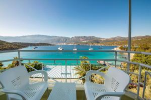 a balcony with white chairs and a view of the water at La Moda Beach Hotel in Kaş