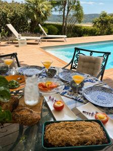 a table with plates of food next to a pool at Atelier Luma in Zikhron Ya'akov
