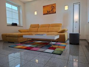 a living room with a couch and a table at Design Ferienhaus Kamerun an der Elbe in Damnatz
